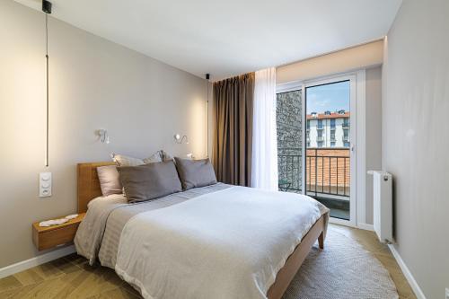 une chambre avec un grand lit et une grande fenêtre dans l'établissement Sun, Style and Comfort - 2BR in Nice Center with Terrace & Garage, à Nice