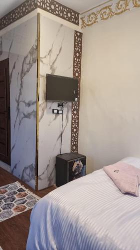 a bedroom with a bed and a tv on a wall at Miracle Pyramids View Hotel in Giza