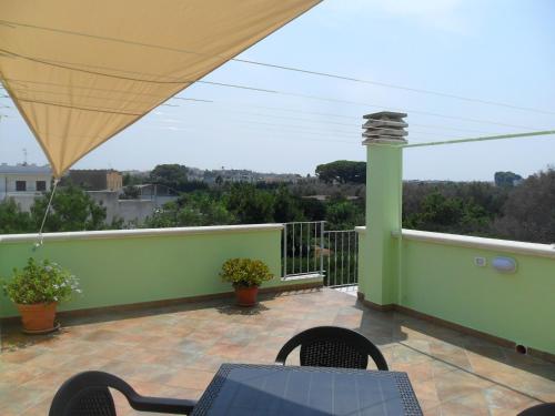 a patio with a table and chairs on a balcony at Domus Rose in Alezio
