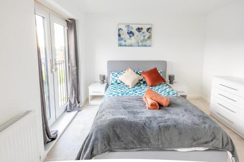 a bedroom with a bed with orange and blue pillows at Joyful Management - A Mordern Semi-Detached House with 3 bedroom in Manchester