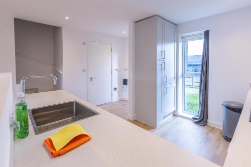 a kitchen with a sink and a counter top at Joyful Management - A Mordern Semi-Detached House with 3 bedroom in Manchester