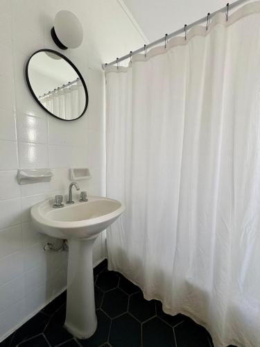 a white bathroom with a sink and a mirror at Luminoso Depto al frente en el corazón del barrio Meridiano V- Meridiano Alquiler Temporario in La Plata