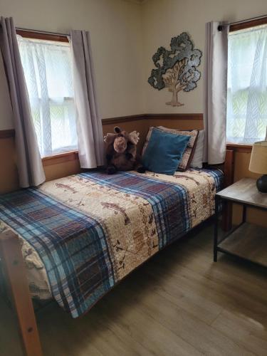 a bedroom with a bed with a teddy bear on it at Castaways Cottage on Croton Pond #5 in Newaygo