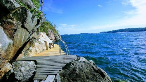 a wooden pathway on the side of a large body of water at 5-star homestay for 2 with breakfast, hot-tub, aircon and bikes in Ingarö
