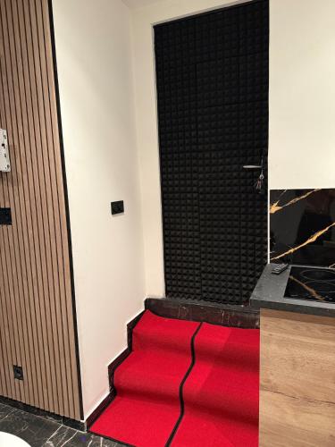 un tapis rouge sur le sol à côté d'une porte dans l'établissement Love dream Toulon, à Toulon
