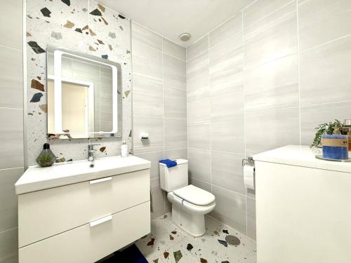 a bathroom with a toilet and a sink and a mirror at Villa Stay & Enjoy in Antigua