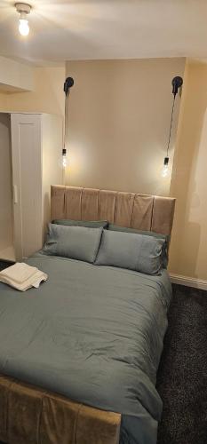 a bedroom with a large bed with blue pillows at Sure stay property in Bolton
