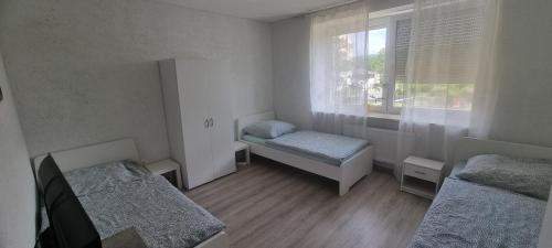 een kleine kamer met twee bedden en een raam bij Arzberger Monteurapartment in Arzberg