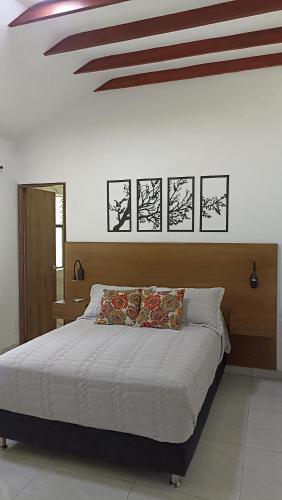 a bedroom with a large bed and a ceiling at Doral House Villavicencio in Villavicencio