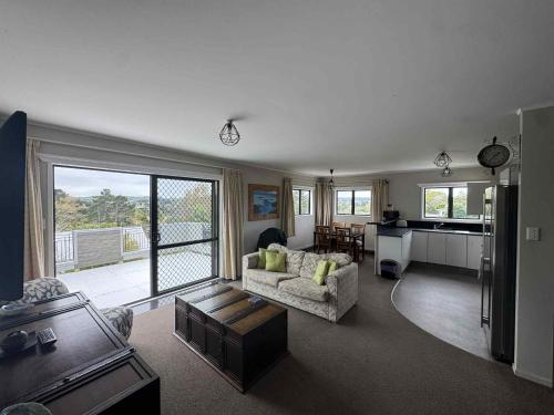 a living room with a couch and a table at Skyline Apartments - Upper Apartment in Raglan