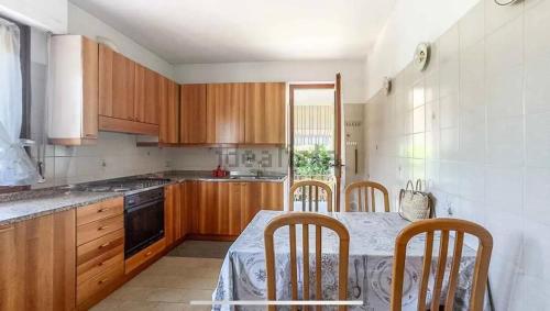 a kitchen with wooden cabinets and a table with chairs at Villa Nice 800m dal mare in Marina di Pietrasanta