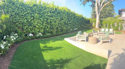 a garden with chairs and grass and a hedge at Montecito-Chic Beachside Retreat in Montecito