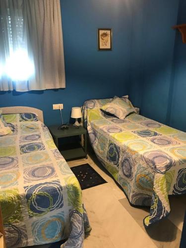a bedroom with two beds and a table with a lamp at ISLANTILLA - URB GREEN 7 in Islantilla