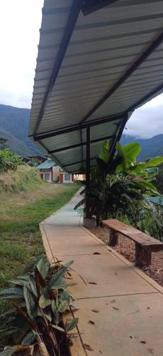awning over a sidewalk with a bench on a hill at Ecoterra Inka Lodge in Santa Ana