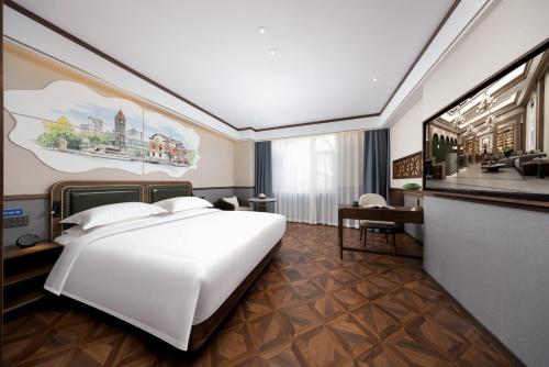 a bedroom with a large white bed and a desk at Nost algia S Hotel Tianjin Ancient Culture Street & The Five Avenues 时光漫步S酒店 天津火车站津湾广场店 Free fresh ground coffee,Free laundry service in Tianjin