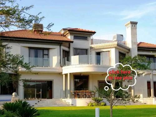 una casa con un cartel delante en The Villa Luxe Hartbeespoort Golf and Wildlife Estate, en Hartbeespoort
