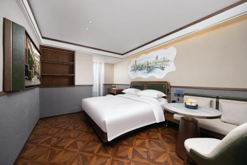 a bedroom with a bed and a table and a couch at Nost algia S Hotel Tianjin Ancient Culture Street & The Five Avenues 时光漫步S酒店 天津火车站津湾广场店 Free fresh ground coffee,Free laundry service in Tianjin
