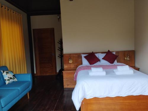 a bedroom with a bed and a blue couch at Ecoterra Inka Lodge in Santa Ana