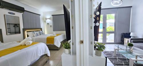 a bedroom with two beds and a living room at Villas at Chalet De Buye in Cabo Rojo