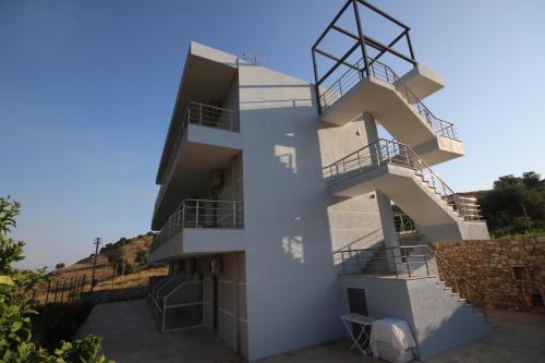 a white house with a spiral staircase at Bujtina Eleni in Himare