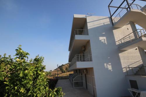 a building with balconies and a blue sky at Bujtina Eleni in Himare