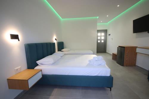 a hotel room with two beds and a tv at Bujtina Eleni in Himare