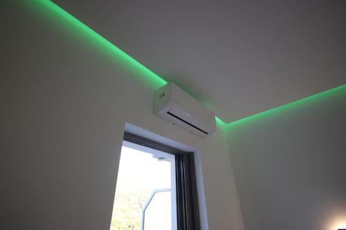 a room with a green ceiling and a window at Bujtina Eleni in Himare