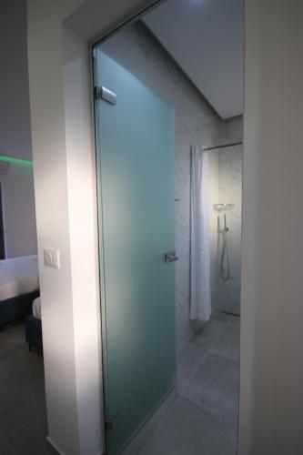 a glass door leading to a shower in a room at Bujtina Eleni in Himare