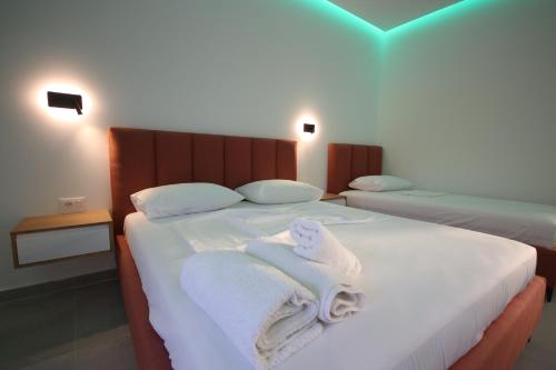 a bedroom with two beds with towels on it at Bujtina Eleni in Himare