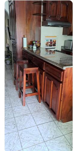 a kitchen counter with a wooden island with a stool at Mobay Oasis in Montego Bay