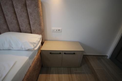 a small bedroom with a bed and a night stand at Bujtina Eleni in Himare
