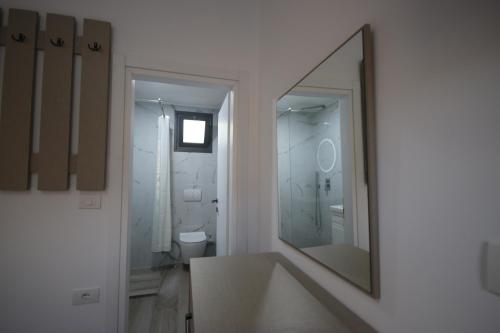 a white bathroom with a sink and a mirror at Bujtina Eleni in Himare