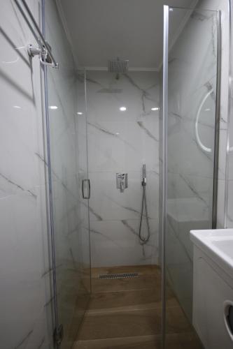 a shower with a glass door in a bathroom at Bujtina Eleni in Himare