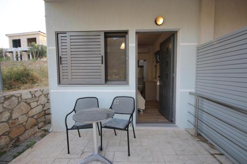a patio with two chairs and a table in front of a house at Bujtina Eleni in Himare