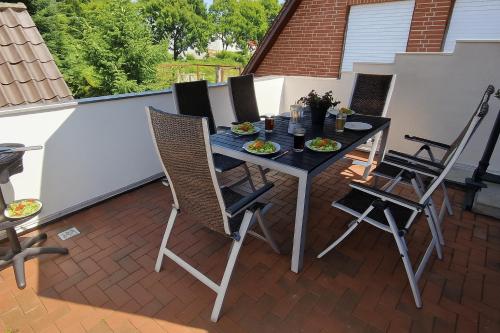 a patio with a table and chairs on a balcony at Ferienwohnung LandLicht mit Terrasse in ruhiger Lage in Sulingen