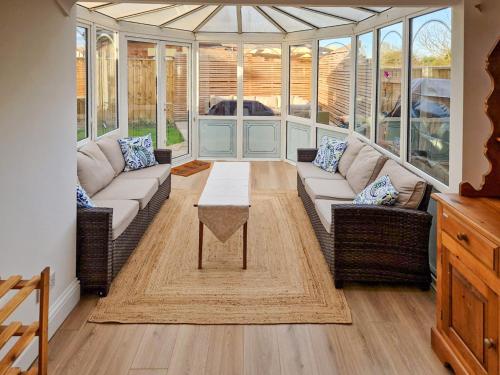a living room with couches and a table in a conservatory at Beaumont in Morpeth
