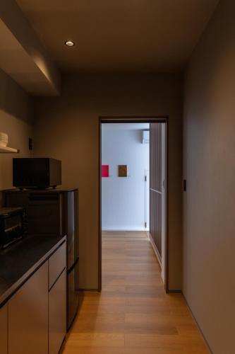 a kitchen with a door leading to a hallway at Flower Base HIMAWARI in Fukuoka