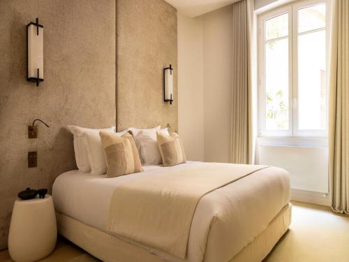une chambre avec un grand lit blanc avec une fenêtre dans l'établissement Luxury flat -3BR 8P- Madeleine Saint Honore, à Paris