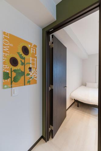 a bedroom with a door leading to a bed at Flower Base HIMAWARI in Fukuoka