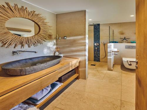 une salle de bain avec un lavabo en pierre et un miroir dans l'établissement Magnificent villa - AC- 5BR-12P- Ramatuelle, à Ramatuelle