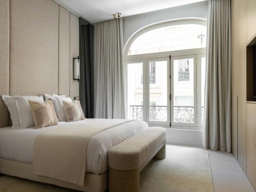 une chambre avec un lit et une grande fenêtre dans l'établissement Luxury flat -2BR 6P- Madeleine Saint Honore, à Paris