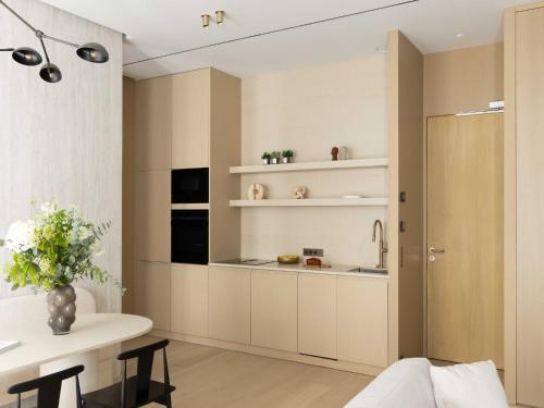 une cuisine avec des armoires blanches et une table dans l'établissement Luxury flat -2BR 6P- Madeleine Saint Honore, à Paris