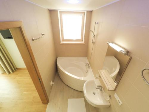 a bathroom with a sink and a toilet and a mirror at BaltHouse Apartments in Jūrmala