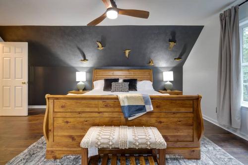 a bedroom with a large wooden bed with a ceiling fan at The Mountain Muse - Music, Games, HotTub, Sleeps12, PetsOk in McGaheysville