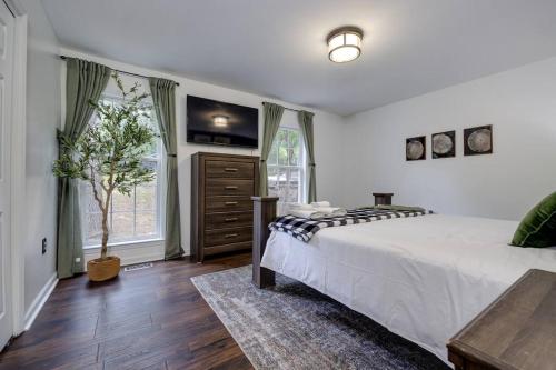 a bedroom with a bed and a tree in it at The Mountain Muse - Music, Games, HotTub, Sleeps12, PetsOk in McGaheysville