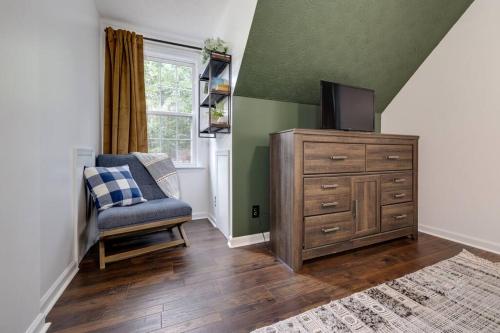 a living room with a tv and a chair and a dresser at The Mountain Muse - Music, Games, HotTub, Sleeps12, PetsOk in McGaheysville