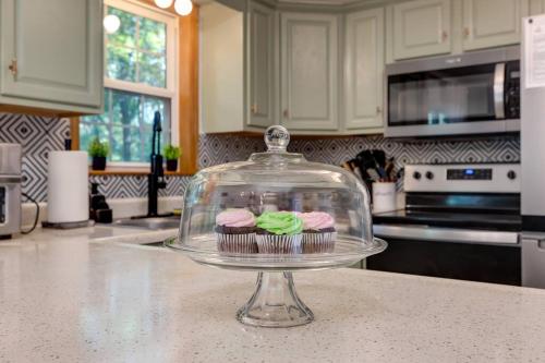 two cupcakes in a glass dish on a kitchen counter at The Mountain Muse - Music, Games, HotTub, Sleeps12, PetsOk in McGaheysville