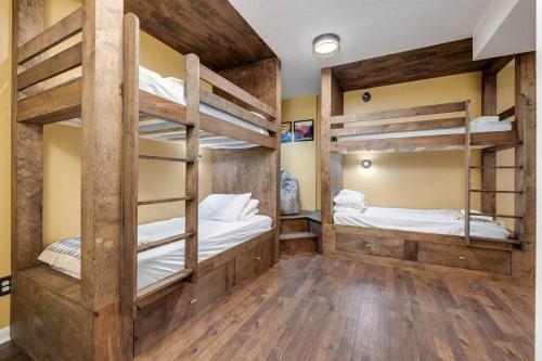 two bunk beds in a room with wooden floors at The Mountain Muse - Music, Games, HotTub, Sleeps12, PetsOk in McGaheysville