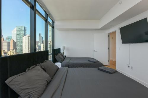 Postel nebo postele na pokoji v ubytování Opulent 2BR Duplex - Iconic Midtown Views