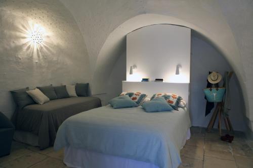 a bedroom with a bed and a couch in it at Palazzina Alchimia in Fasano